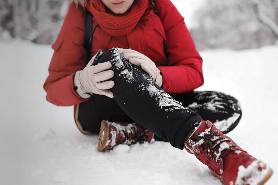 Photo of a person holding their knee in pain