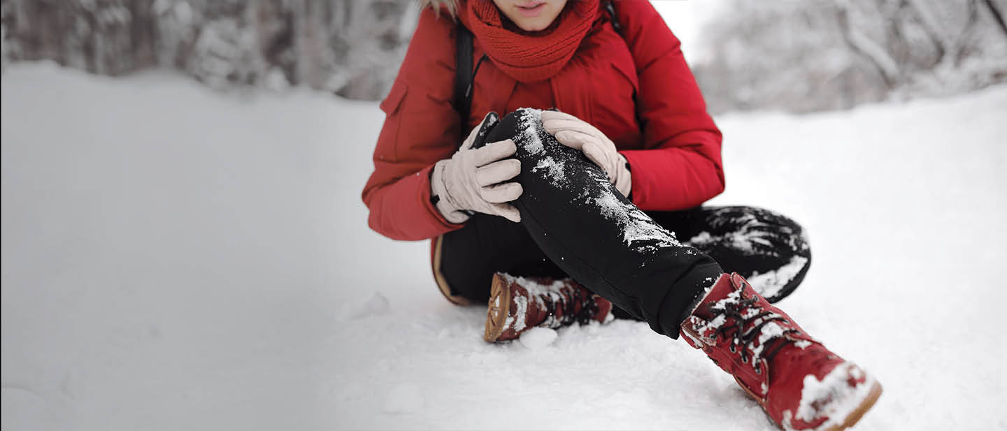 Photo of a person holding their knee in pain